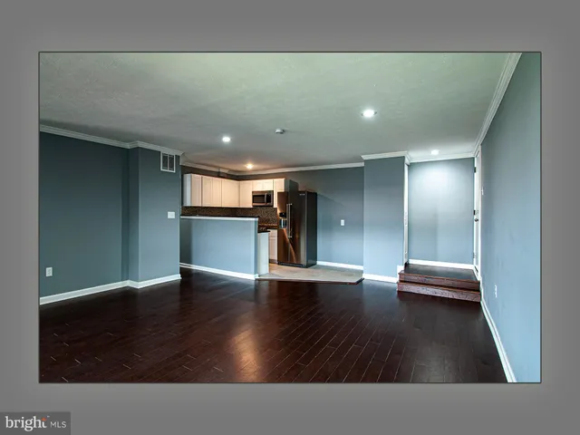 a view of hallway with stairs and wooden floor