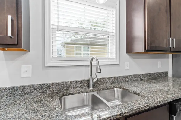 a kitchen with granite countertop a sink and a window