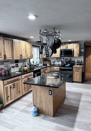 88 Lord Hill Road Rindge, NH 03461 - Photo 4 of 8 a kitchen with stainless steel appliances granite countertop a stove a sink and a microwave