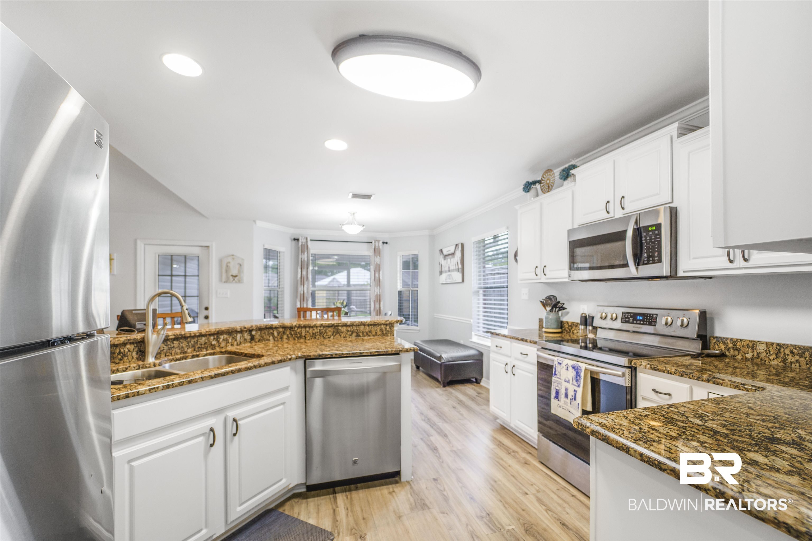 4620 Pine Boulevard Orange Beach, AL 36561 - Photo 12 of 49 Kitchen with stainless steel appliances, light wood-style floors, white cabinetry, dark stone counters, and recessed lighting