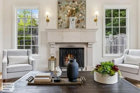 a living room with furniture fireplace and a large window