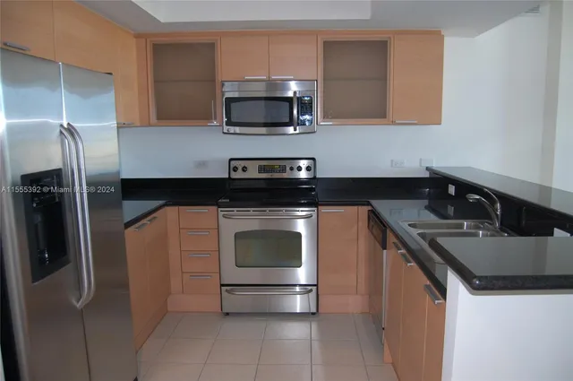 a kitchen with a sink and steel appliances