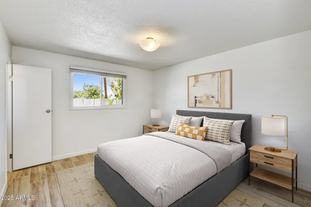 a bedroom with a bed and painting on the wall