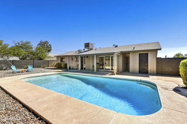 a view of a house with swimming pool and sitting area