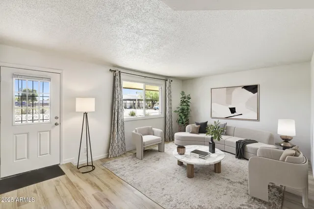 a living room with furniture a window and a wooden floor