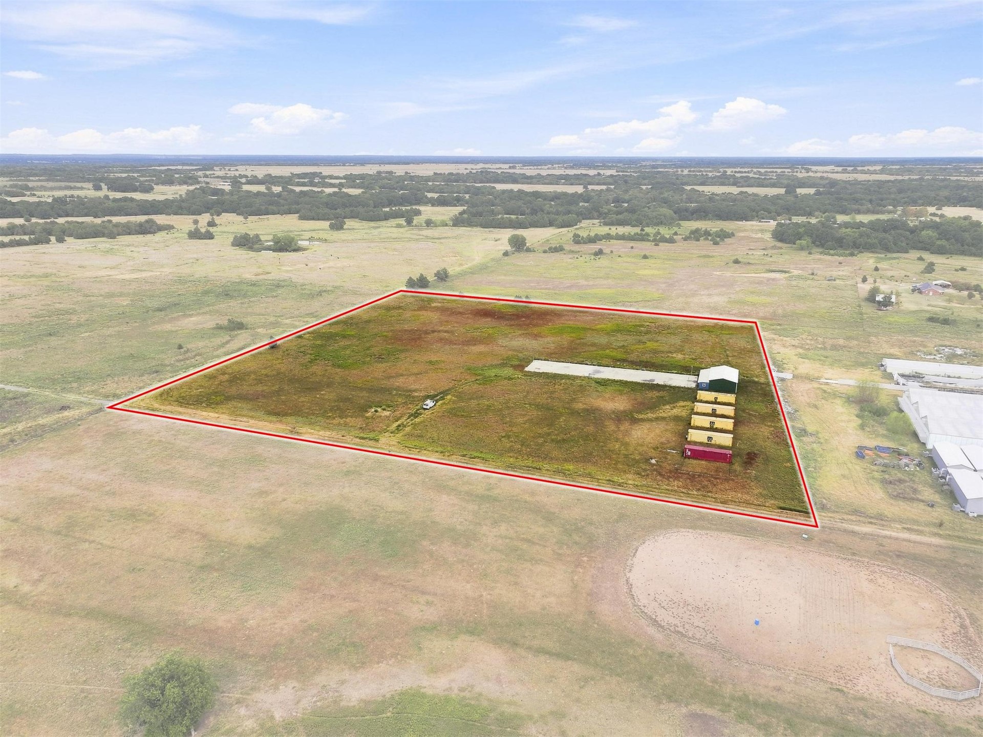 180 Tower Road Bokchito, OK 74726 - Photo 1 of 49 Expansive land parcel featuring open fields and a long, narrow building
