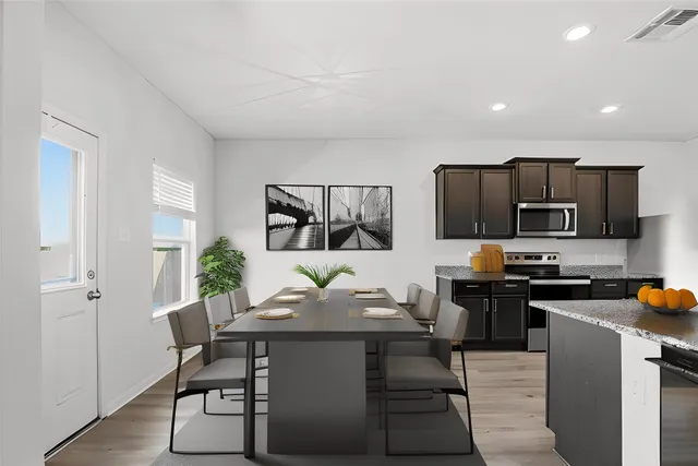 a kitchen with stainless steel appliances granite countertop a refrigerator a stove top oven a sink and dishwasher