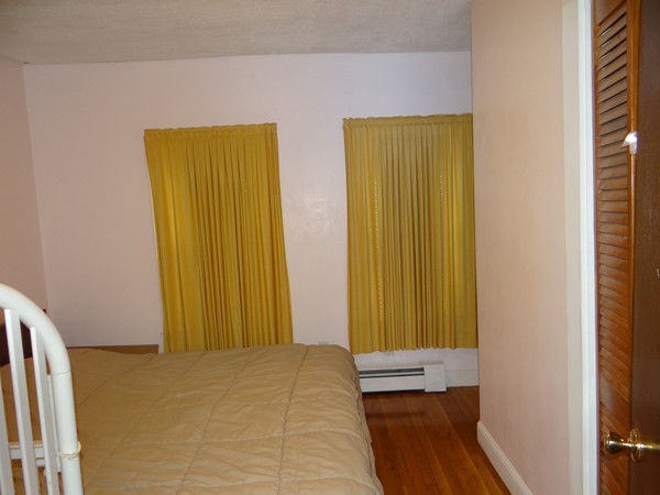 159 Sturges Street Medford, MA 02155 - Photo 8 of 12 a bedroom with a bed and wooden floor