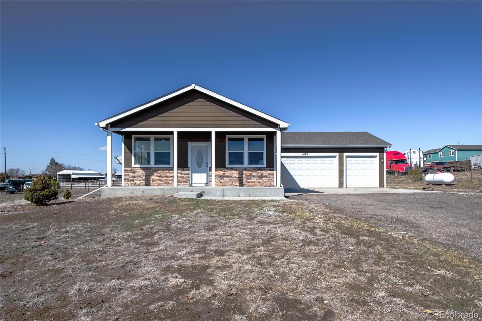 1445 4th Place Deer Trail, CO 80105 - Photo 1 of 19 a front view of a house with a yard and garage