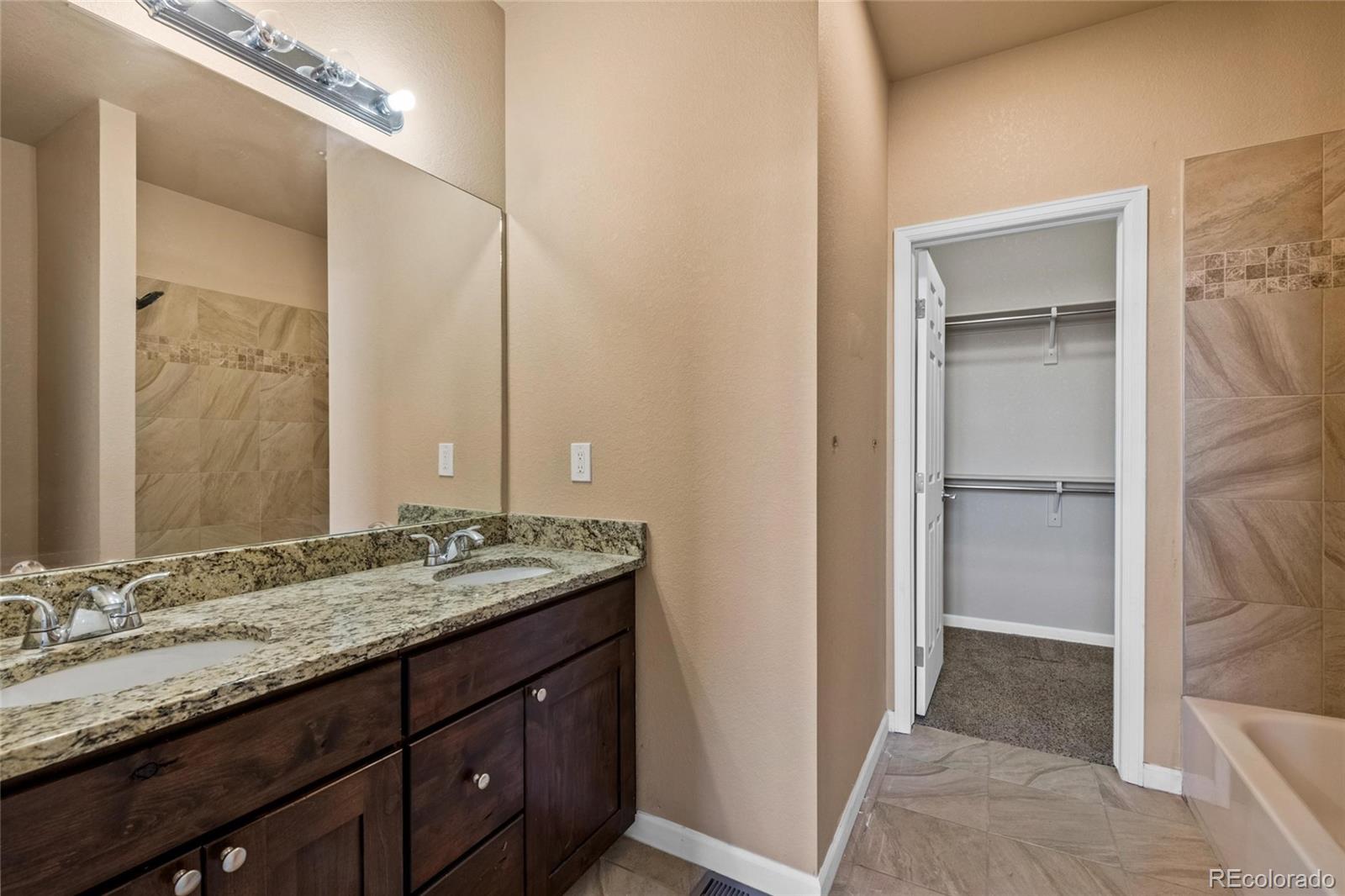 1445 4th Place Deer Trail, CO 80105 - Photo 15 of 19 a bathroom with a granite countertop sink and a mirror