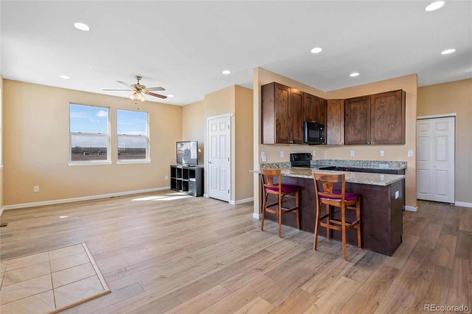 1445 4th Place Deer Trail, CO 80105 - Photo 7 of 19 a kitchen with stainless steel appliances granite countertop a refrigerator a stove top oven and a sink with cabinets