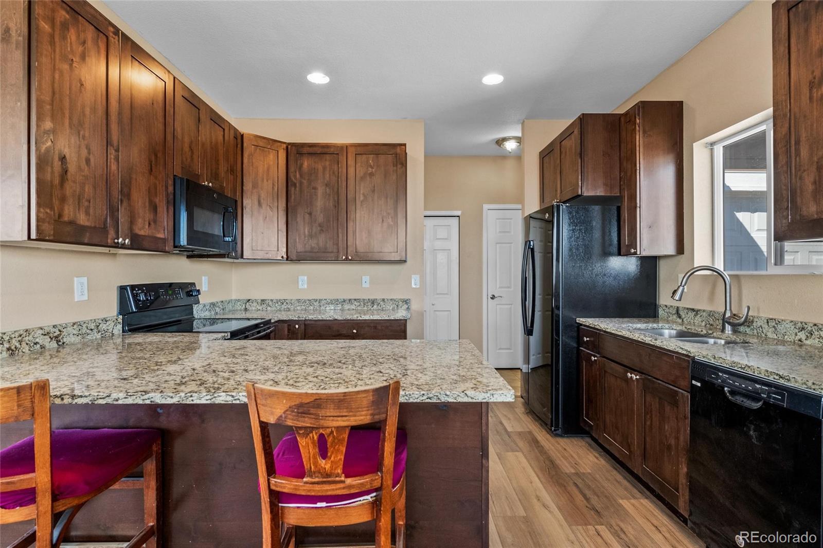 1445 4th Place Deer Trail, CO 80105 - Photo 8 of 19 a kitchen with stainless steel appliances granite countertop a refrigerator a stove top oven a sink and dishwasher