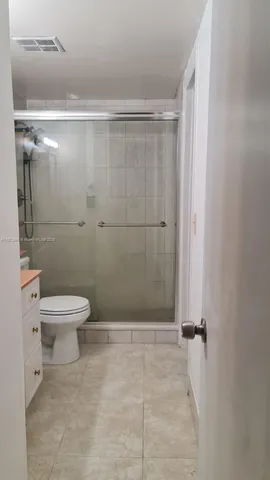 a bathroom with a granite countertop toilet sink and mirror