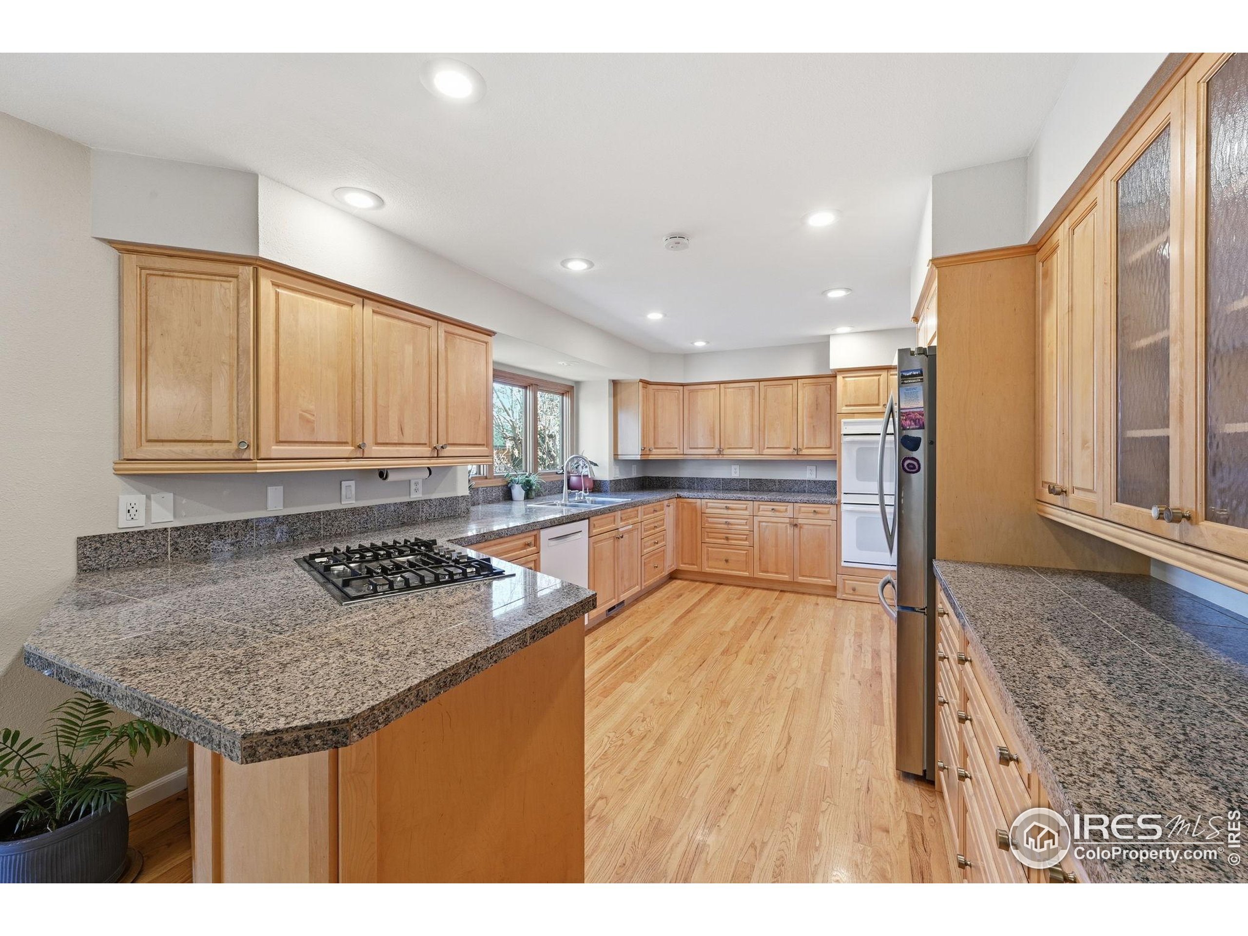 2158 Rockspray Court Longmont, CO 80503 - Photo 15 of 35 a kitchen with granite countertop a stove and a sink