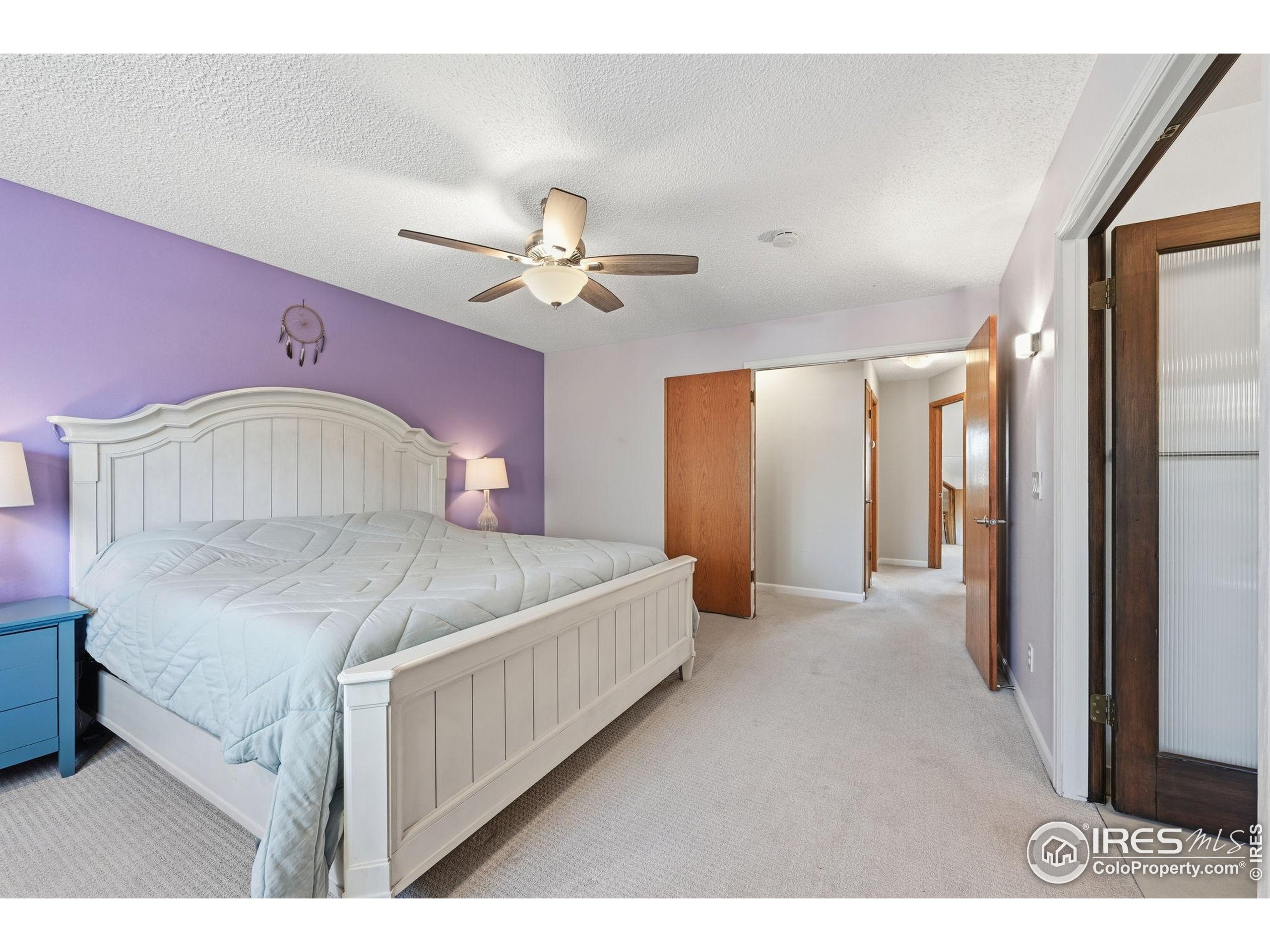 2158 Rockspray Court Longmont, CO 80503 - Photo 25 of 35 a bedroom with a large bed and a chandelier