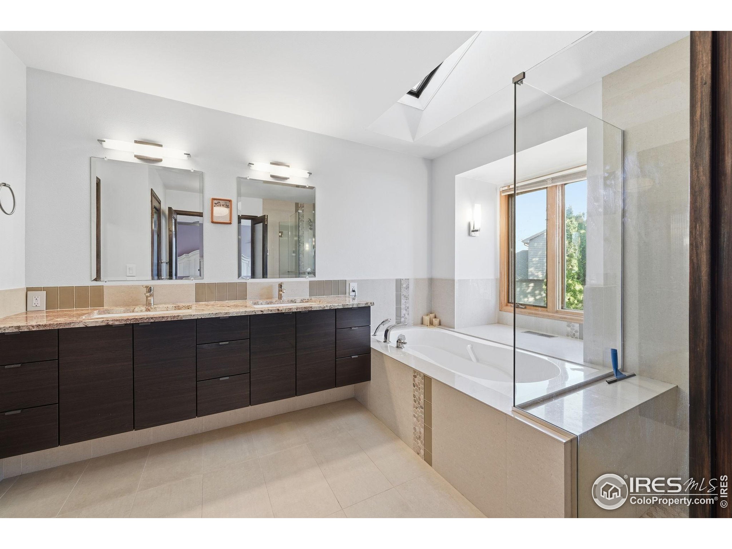 2158 Rockspray Court Longmont, CO 80503 - Photo 26 of 35 a spacious bathroom with a tub sink and mirror