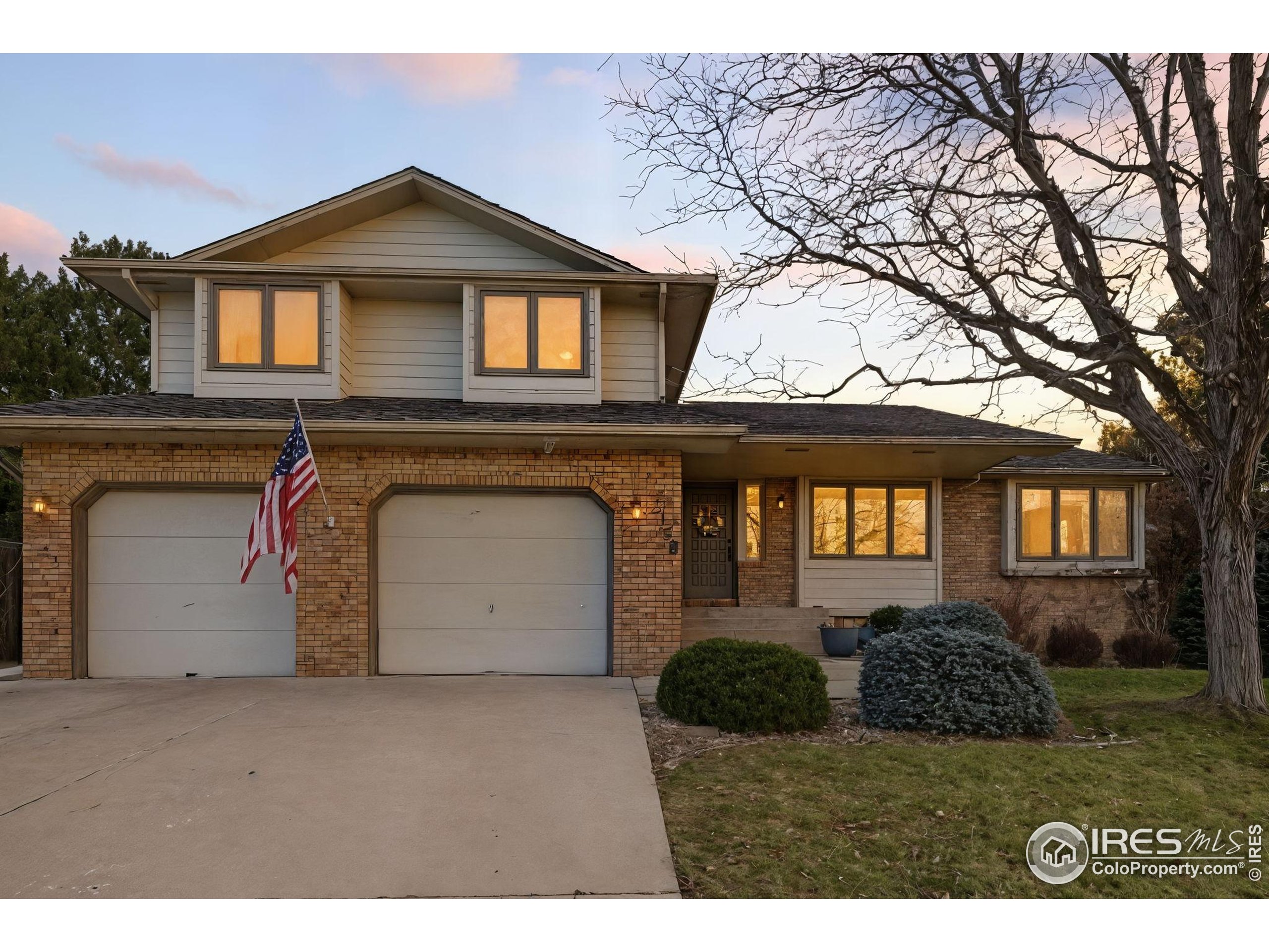 2158 Rockspray Court Longmont, CO 80503 - Photo 4 of 35 a front view of a house with a garden and trees