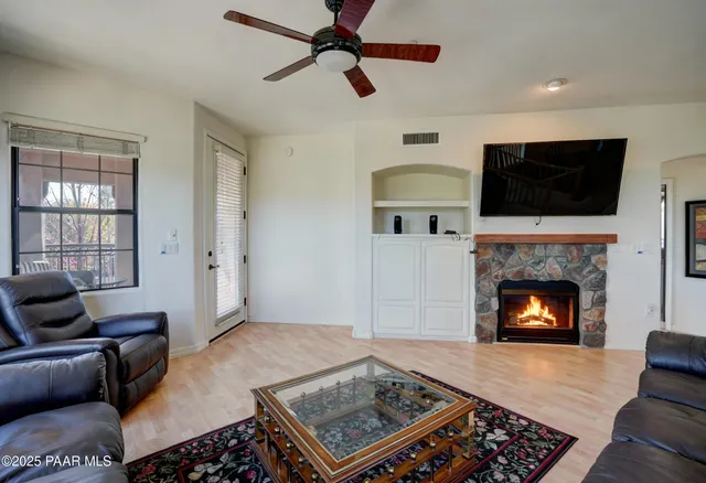a living room with furniture a flat screen tv and a fireplace