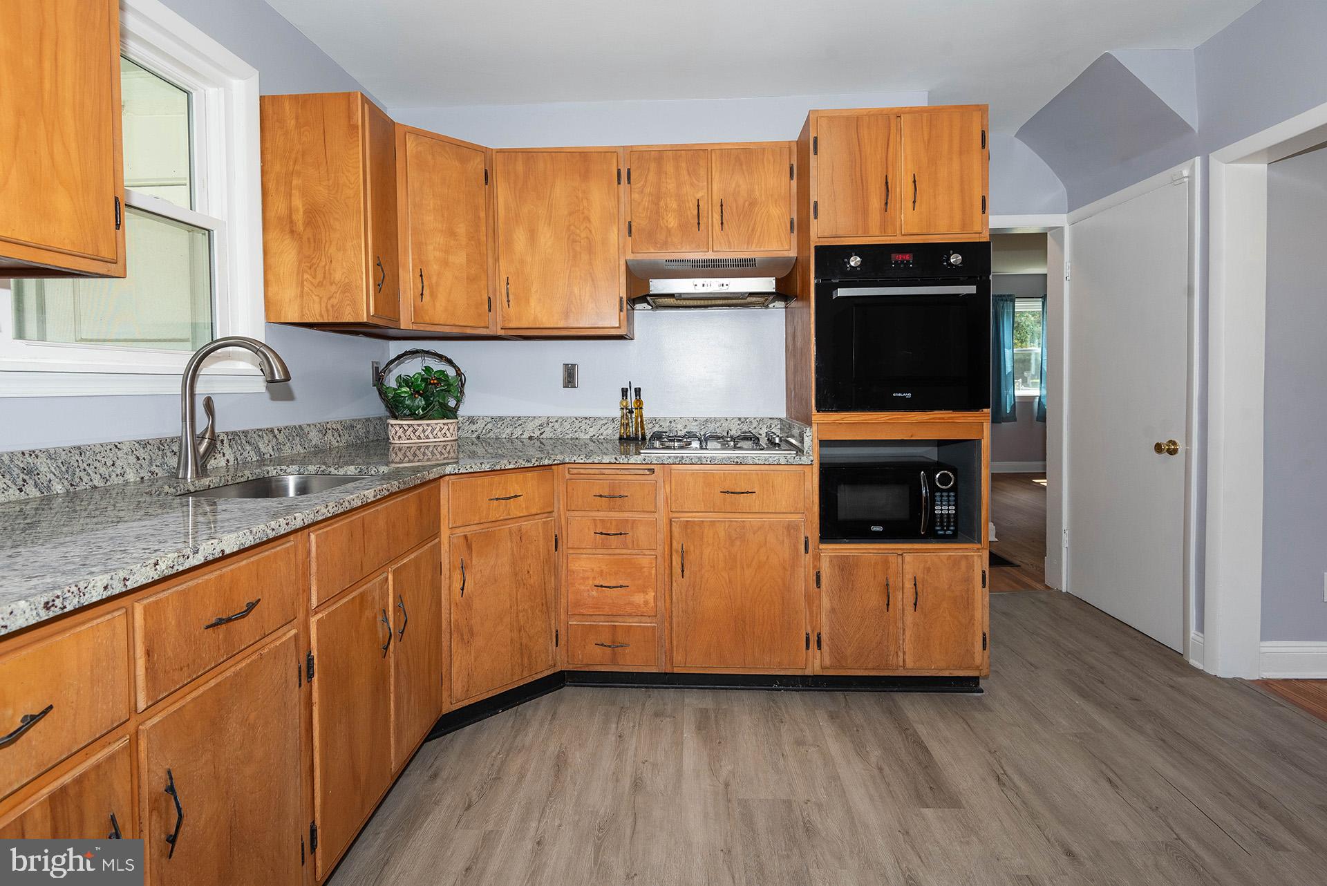 4506 Morgan Road Morningside, MD 20746 - Photo 7 of 22 a kitchen with granite countertop a sink a stove and cabinets