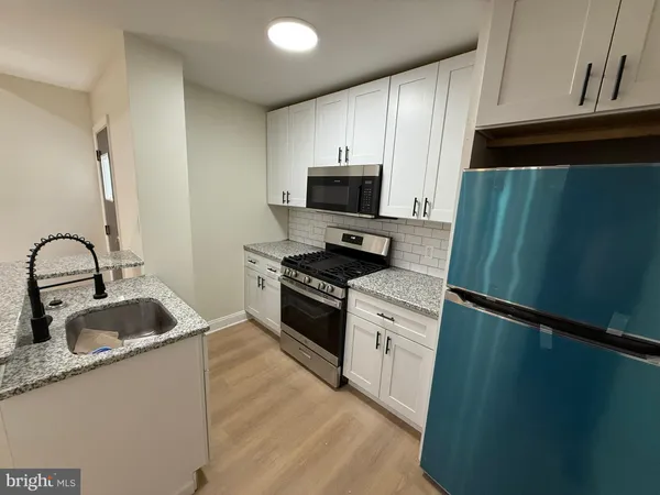 a kitchen with granite countertop a refrigerator and a sink
