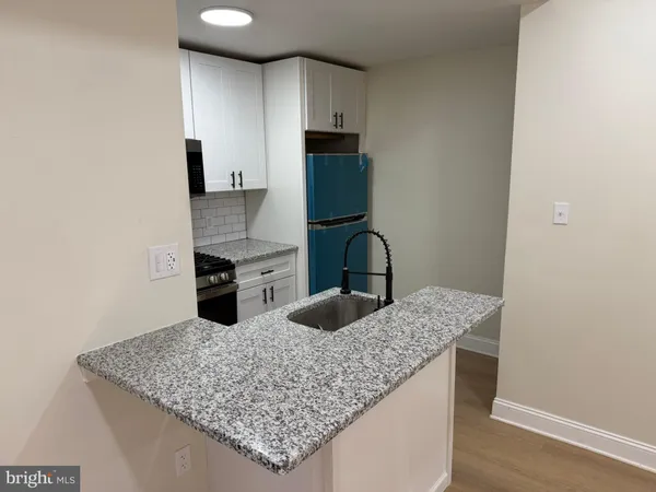 a kitchen with granite countertop a sink and a stove