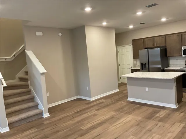 a kitchen with stainless steel appliances a sink a stove a microwave a sink a refrigerator and cabinets