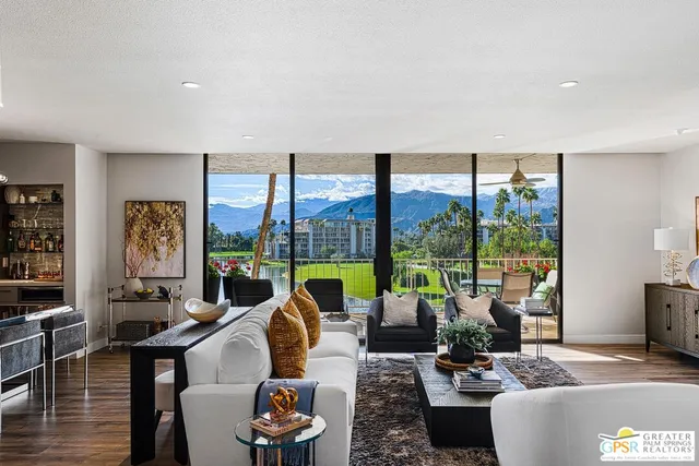 a living room with fireplace furniture and a large window