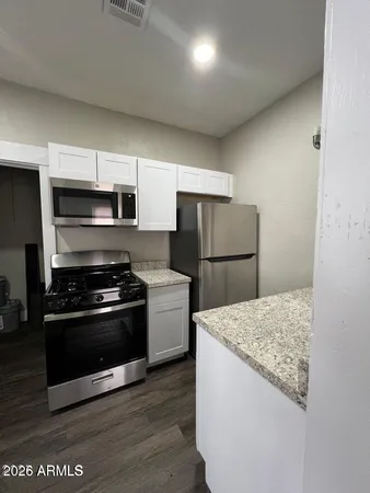 a kitchen with a refrigerator and a stove top oven