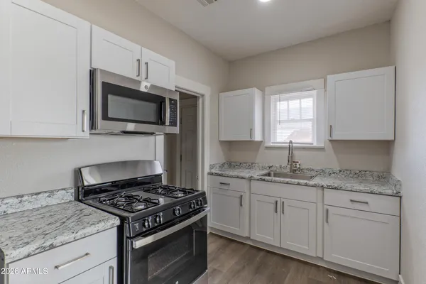 a kitchen with granite countertop a stove and a sink