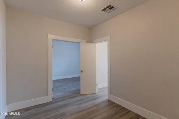a view of an empty room with wooden floor