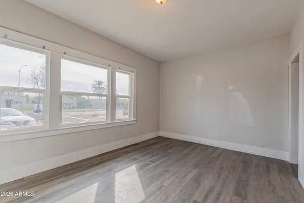 a view of empty room with wooden floor and fan