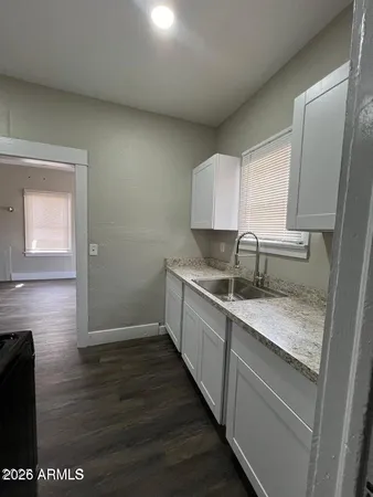 a kitchen with sink cabinets and wooden floor