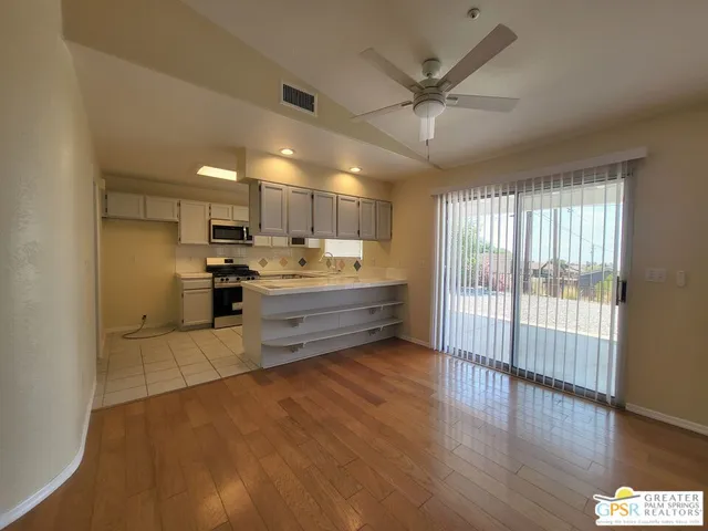 a kitchen with kitchen island granite countertop a sink cabinets and stainless steel appliances