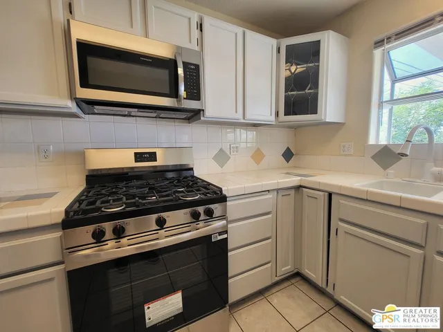 a stove top oven sitting inside of a kitchen