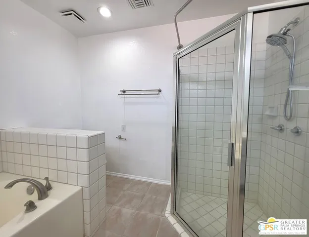 a bathroom with a tub sink shower and mirror