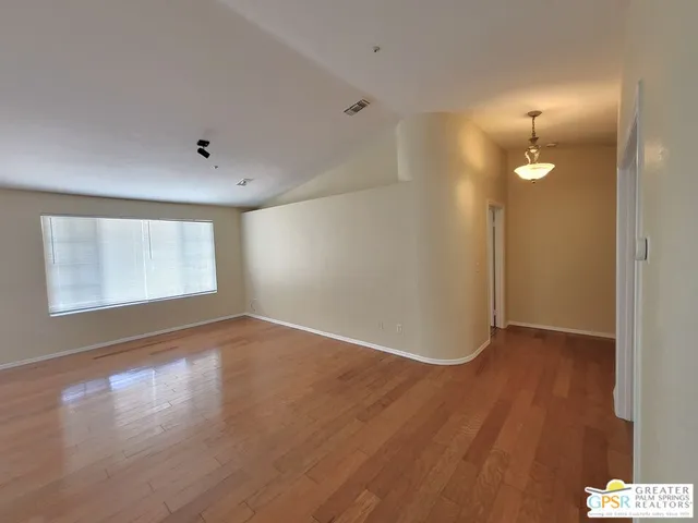a living room with stainless steel appliances furniture a fireplace and a kitchen view