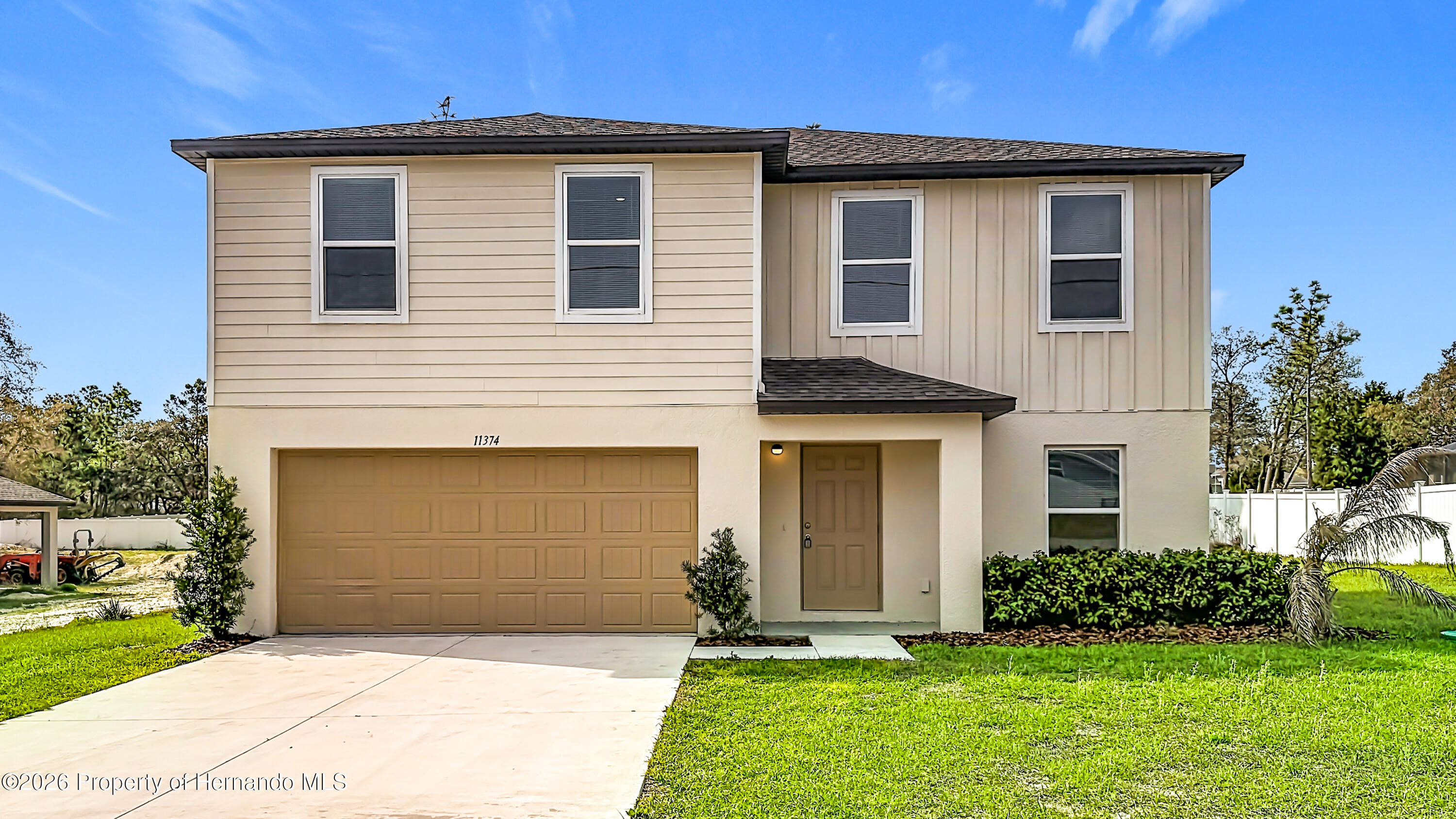 11374 Marcella Avenue Weeki Wachee, FL 34614 - Photo 2 of 70 a front view of a house with a yard and garage