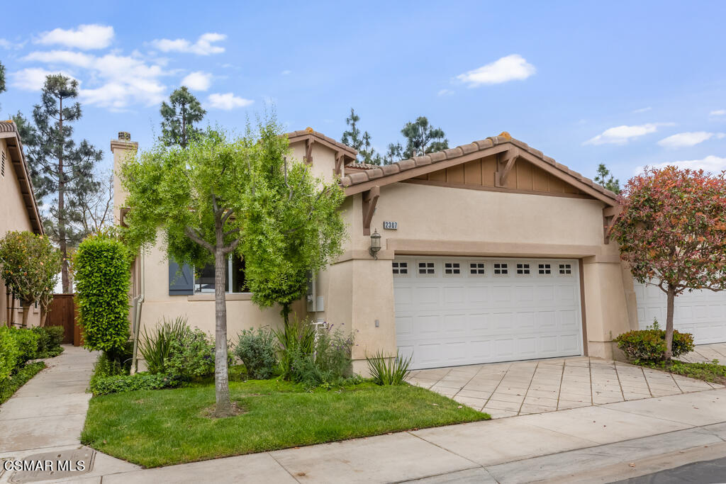 2307 Shakespeare Drive Oxnard, CA 93033 - Photo 2 of 42 a front view of a house with a yard and garage