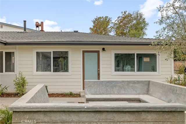 a open kitchen with stainless steel appliances kitchen island a white table chairs and a refrigerator