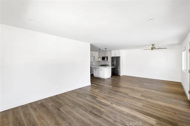 a view of an empty room with wooden floor and closet