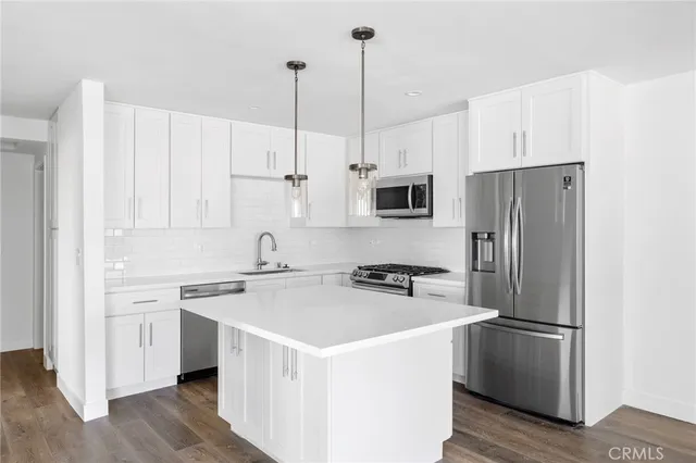 a kitchen with stainless steel appliances granite countertop a refrigerator sink and stove