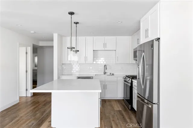 a kitchen with stainless steel appliances a refrigerator and a stove top oven