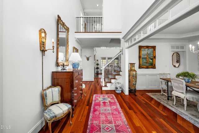a living room with furniture a chandelier a large window and wooden floor