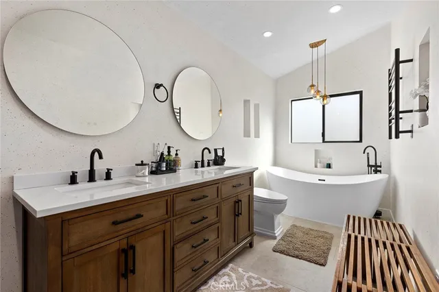 a spacious bathroom with a double vanity sink double mirror and bathtub