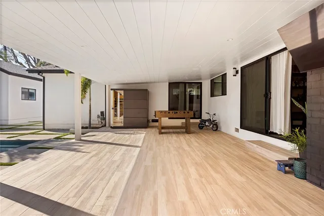 a living room with furniture a flat screen tv and a floor to ceiling window