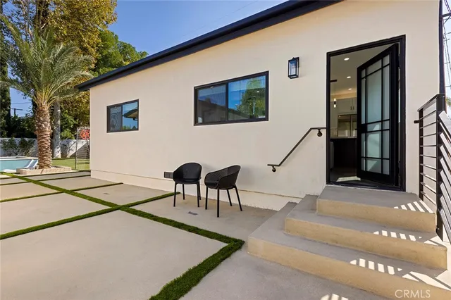 a kitchen with kitchen island granite countertop a stove a sink a refrigerator and white cabinets with wooden floor