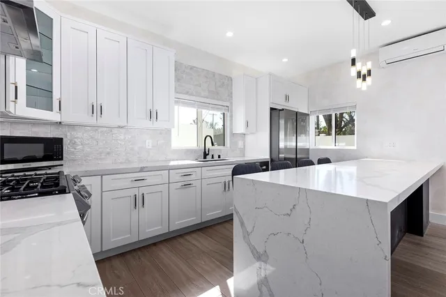 a kitchen with a white cabinets and living room view