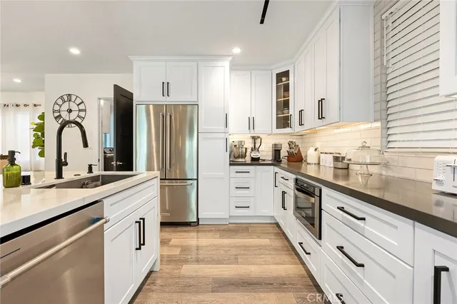 a kitchen with stainless steel appliances granite countertop a refrigerator sink and cabinets