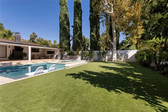 a house view with swimming pool in front of it