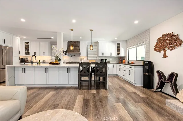a living room with stainless steel appliances kitchen island granite countertop furniture a refrigerator a stove a sink dishwasher with a dining table and chairs